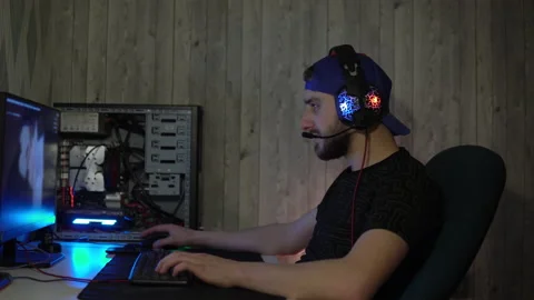A guy in headphones plays computer games, speaks into a microphone and breaks Video stock 149217550