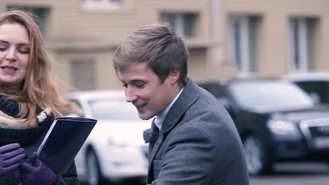 The guy helps the girl to get into the car. Stock Footage 80507680