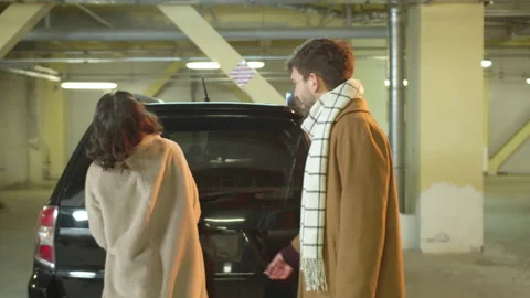 The guy helps a woman open the trunk of a car Stock Footage 130363152