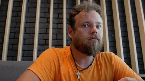 Guy hipster with a beard eats pizza and turns his gaze to the camera.4k. Stock Footage 111383403