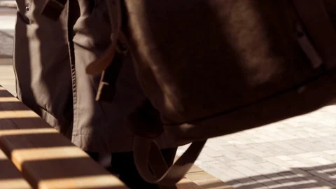 Guy hipster operator in the sunny courtyard opens the backpack and takes out a Stock Footage 106880243