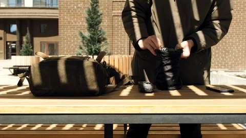 Guy hipster operator in the sunny courtyard opens the backpack and takes out a Stock Footage 106881940