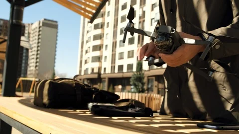 Guy hipster operator in the sunny courtyard opens the backpack and takes out a Stock Footage 106885446
