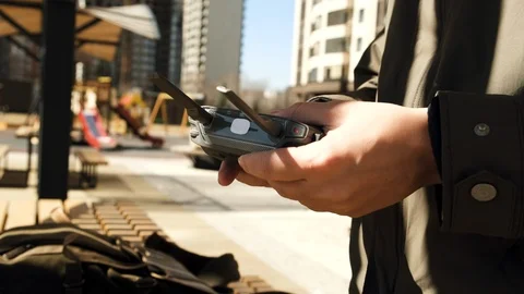Guy hipster operator in the sunny courtyard opens the backpack and takes out a Stock Footage 106886467