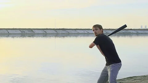 Guy hit a fruit bat slow motion. Man break vegetable piece. Baseball slowmotion. Stock Footage 72548986