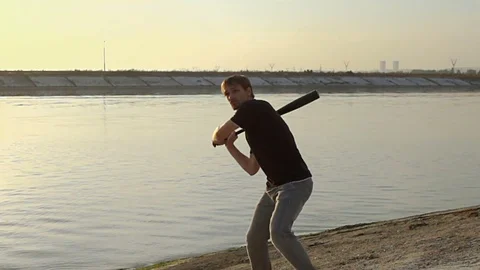 Guy hit a fruit bat slow motion. Man break vegetable piece. Baseball slowmotion. Stock Footage 72550403