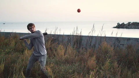 Guy hit a fruit bat slow motion. Man break vegetable piece. Baseball slowmotion. Stock Footage 72551524