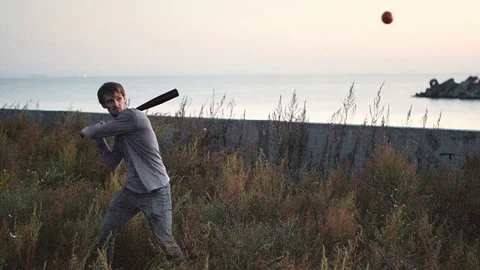 Guy hit a fruit bat slow motion. Man break vegetable piece. Baseball slowmotion. Stock Footage 72551755