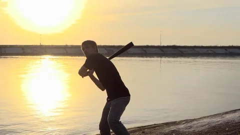 Guy hit a fruit bat slow motion. Man break vegetable piece. Baseball slowmotion. Stock Footage 72557984