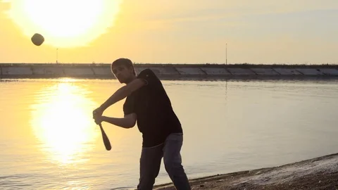 Guy hit a fruit bat slow motion. Man break vegetable piece. Baseball slowmotion. Stock Footage 72558232