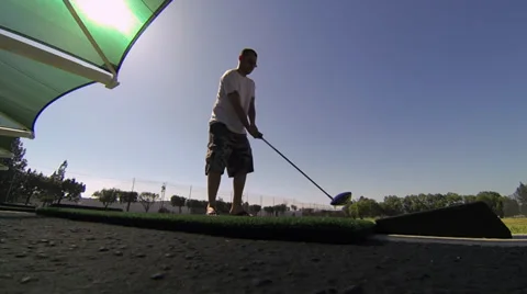 Guy hits golf ball Vídeo Stock 35522640