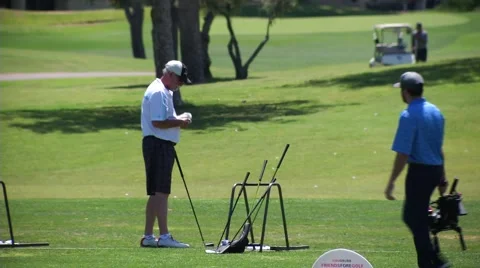Guy hitting golf balls on golf course wide shot Stock Footage 62846233