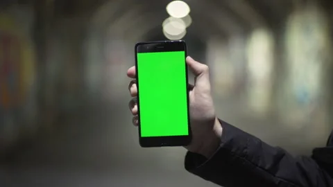 Guy holding in arms electronics gadget with green screen touchpad, scrolling and Stock Footage 134383598