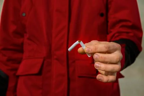 The guy is holding a broken cigarette. 스톡 사진