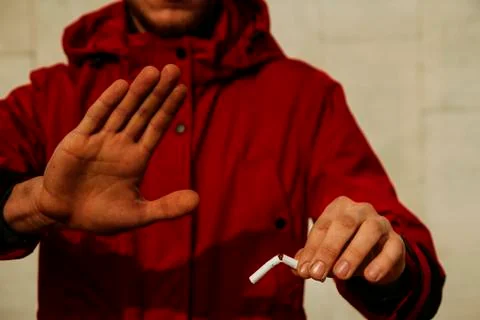 The guy is holding a broken cigarette. Stockfoto's