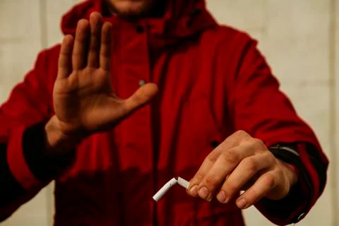 The guy is holding a broken cigarette. 写真素材