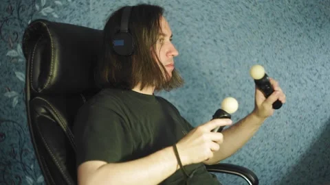 The guy is holding motion controllers and playing a video game Stock Footage 131792052