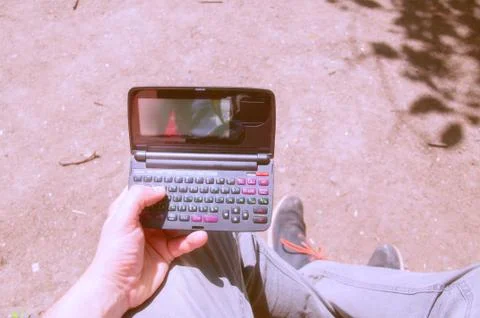 The guy is holding an old microcomputer. The obsolete device. A young guy tri Stock Photos