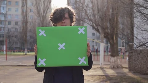Guy holding a picket poster, poster with a green background for text, single  Stock-Footage 125911377