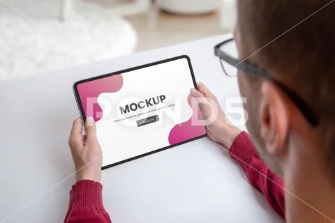 Guy holding tablet mockup on work desk PSD Template
