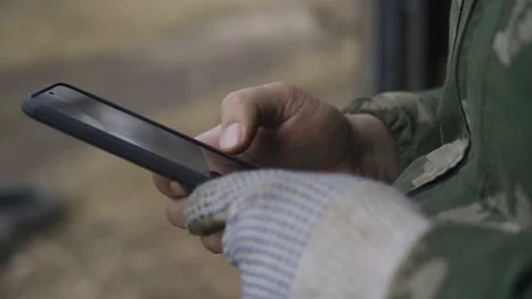 The guy holds a black mobile phone in his hands and, distracted from work Stock Footage 152055632