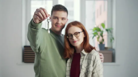 The guy holds a bunch of keys in front of the camera and hugs his girlfriend Stock Footage 151494843