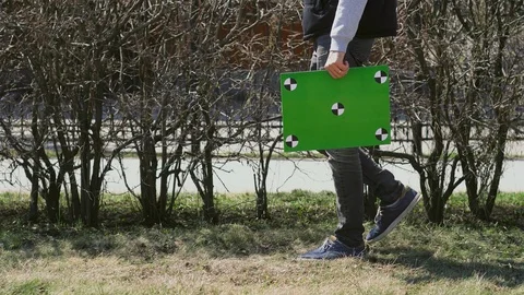 Guy holds chroma key poster, could be a postman. Man's table with motion points. Stock Footage 106555252