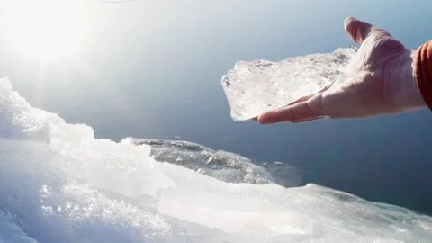 The guy holds clean and transparent ice in his hand. A piece of pure ice. Stock Footage 239993373