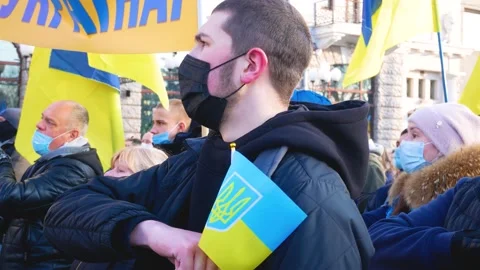The guy holds his hand to his heart and sings the anthem of Ukraine at a rally Stock Footage 214861483