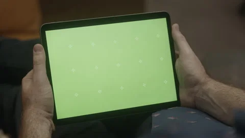 Guy holds iPad on couch with green screen mockup (2 of 3) Stock Footage