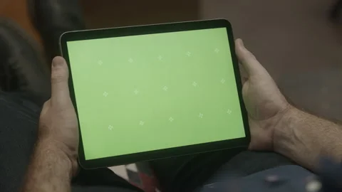 Guy holds iPad on couch with green screen mockup (3 of 3) Stock Footage
