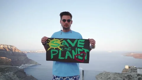 The guy holds a large poster in his hands with the words "Save the Planet" Stock Footage 159586773