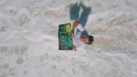 The guy holds a poster with the words "Save the Planet" Stock Footage 153540684