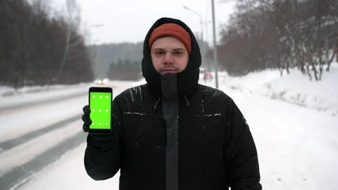 The guy holds the smartphone screen to the camera during a winter walk. Points Stock Footage 168373132