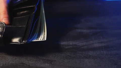 The guy holds a wallet with dollars and coins in the form of bitcoin Stock Footage 101514473