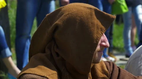 Guy in the hood sits on the grass and looks away Stock Footage 82408226