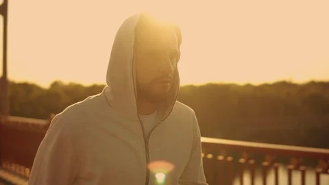 Guy in hoodie having intensive training outdoors Stock Footage 92023465