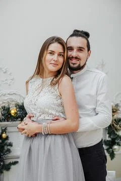 A guy hugs his elegantly dressed girl at the New Year's holiday Stock Photos