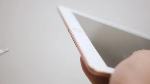 The guy inserts the cable to charge the tablet. Close-up. Stockbeeldmateriaal 150331924