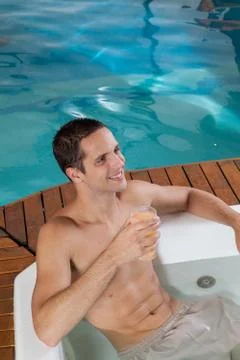 Guy inside a jacuzzi drinking juice Stock Photos