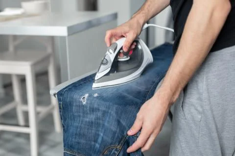 A guy ironing clothes before going outside Stock Photos