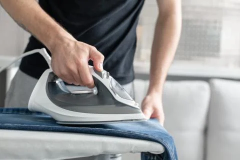A guy ironing clothes before going outside Stock Photos