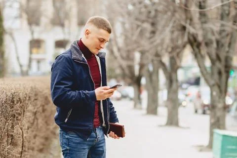 Guy in jacket simple stands with phone Stock Photos