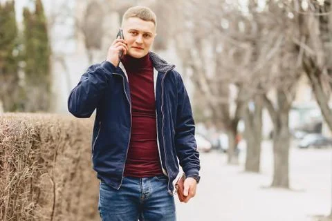 Guy in jacket simple stands with phone Stock Photos