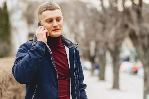 Guy in jacket simple stands with phone Stock Photos