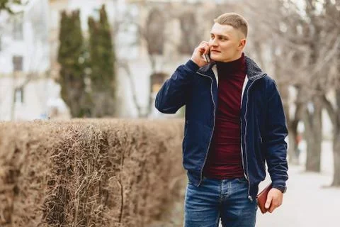 Guy in jacket simple stands with phone Stock Photos