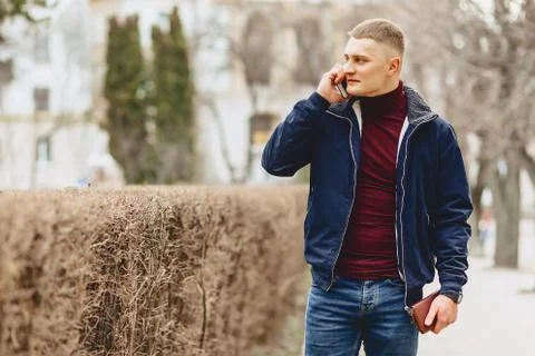 Guy in jacket simple stands with phone Stock Photos