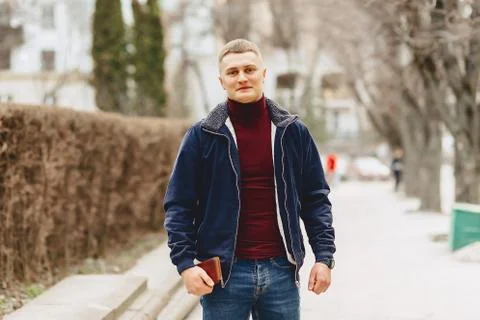 Guy in jacket simple stands with phone Stock Photos