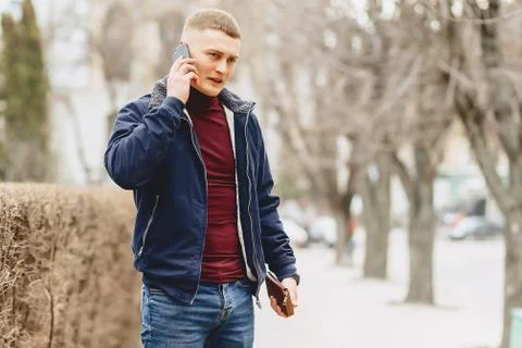 Guy in jacket simple stands with phone Stock Photos