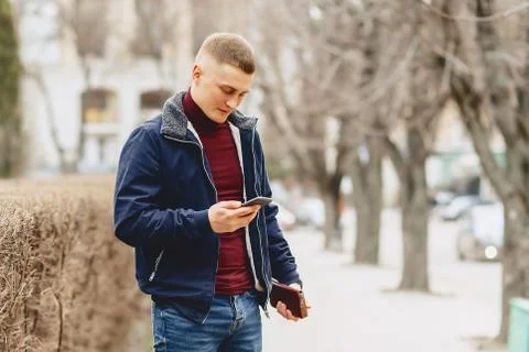 Guy in jacket simple stands with phone Stock Photos